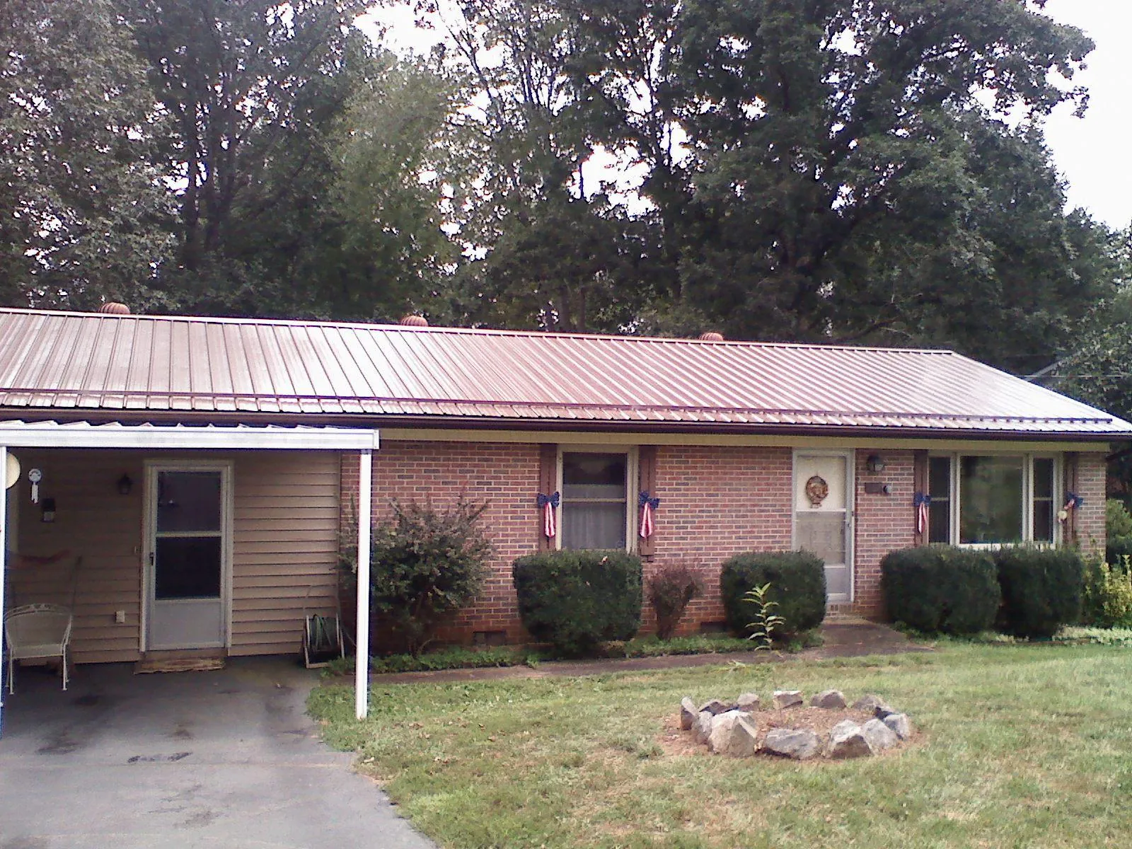 Bronze metal roof and carport on a brick ranch home — Roof Repair work by our crew in Starke